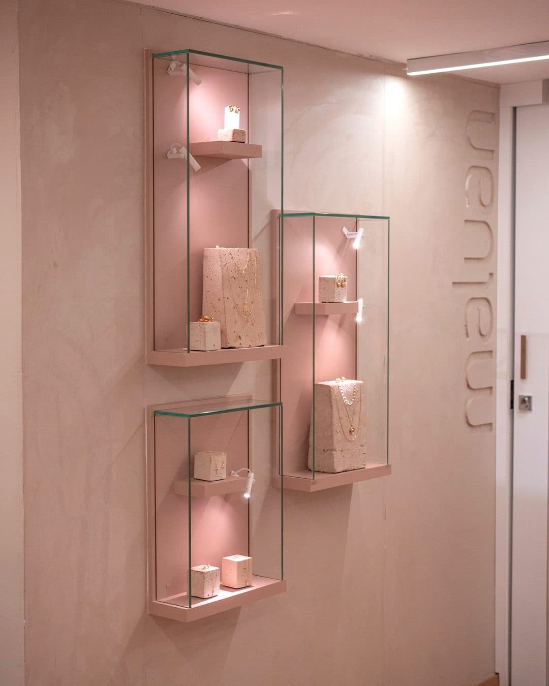 Vitrine de semijoias iluminada em parede rosa